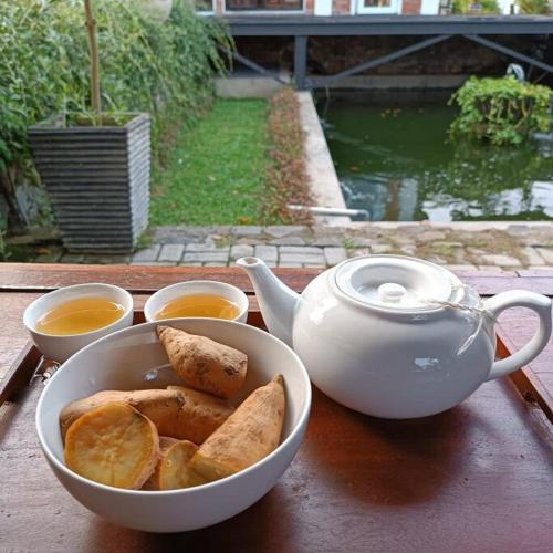 een kom met brood en een theepot op een tafel bij Villa Arum Dalu in Semplak