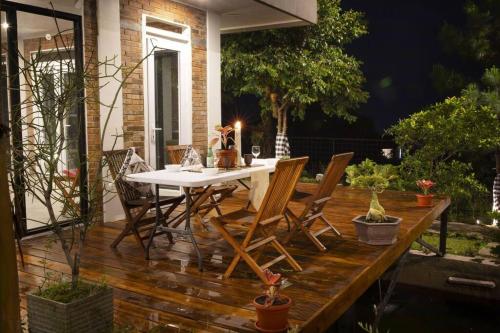 a wooden deck with a table and chairs on it at Villa Arum Dalu in Semplak