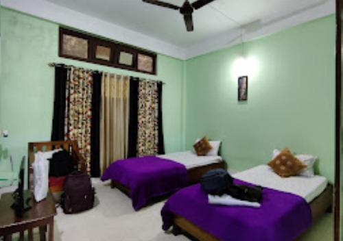 duas camas num quarto com roxo e branco em Hotel Mandal Ghang Arunachal Pradesh em Bhalukpung