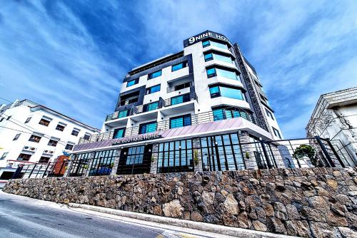 a tall white building with a fence in front of it at Nine Boutique Hotel in Seogwipo