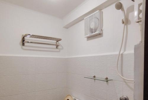 a white bathroom with a shower and a toilet at RedDoorz @ The Central Inn Boracay Island in Boracay