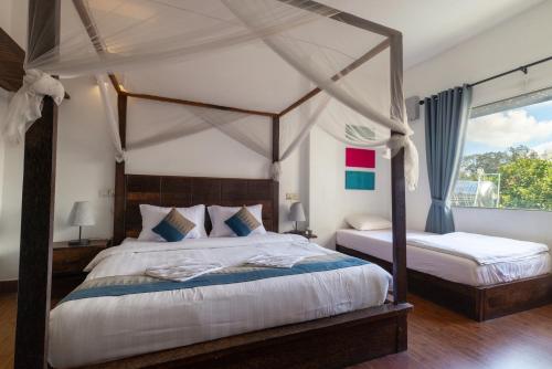 um quarto com 2 camas e uma cama de dossel em Suite Home Boutique Hotel em Phnom Penh