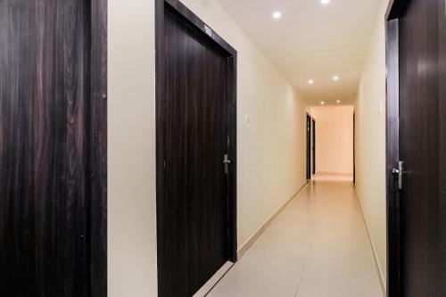 a hallway with black doors and white walls at OYO Pradhann Home Stay in Kalimpong