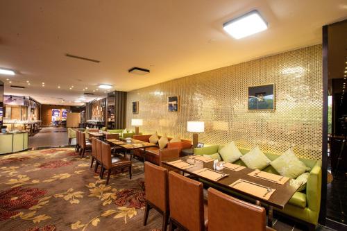 a restaurant with tables and chairs in a room at Hilton Nanjing Riverside in Nanjing