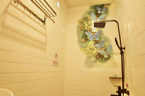 a bathroom with a shower with butterflies on the wall at Hoàng Tây Hotel - Đồng Tháp in Ấp Hòa Lạc