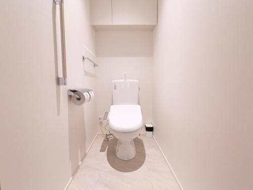 a white bathroom with a toilet in a stall at GRAND BASE Hiroshima Peace Memorial Park in Hiroshima