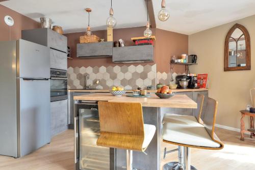 a kitchen with a table and a refrigerator at T3 with balcony near the Stade de France - Welkeys in Saint-Denis