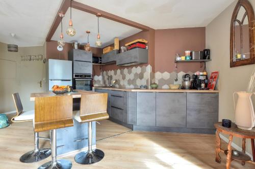 une cuisine avec des placards gris et un comptoir dans l'établissement Appartement Olympe - Welkeys, à Saint-Denis