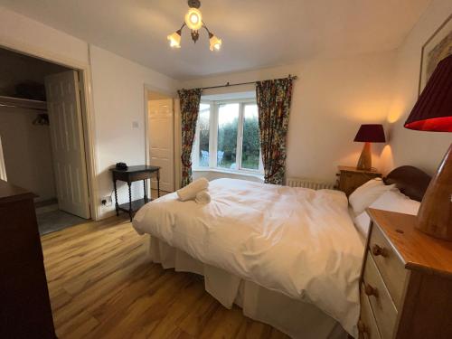 a bedroom with a white bed and a window at Wild Atlantic Way Cottage Galway in Galway