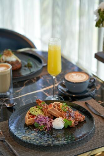 a table with a plate of food and a glass of orange juice at Waldorf Astoria Dubai International Financial Centre in Dubai
