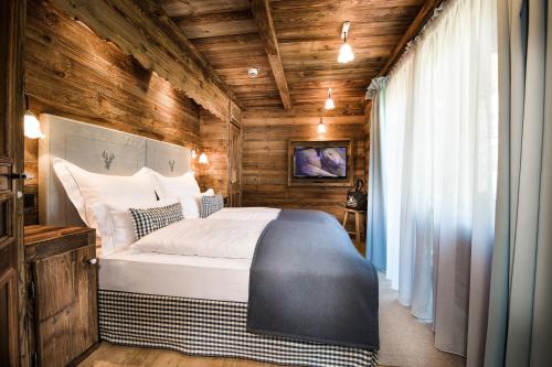 a bedroom with a large bed in a room with wooden walls at MONDI Resort und Chalet Oberstaufen in Oberstaufen
