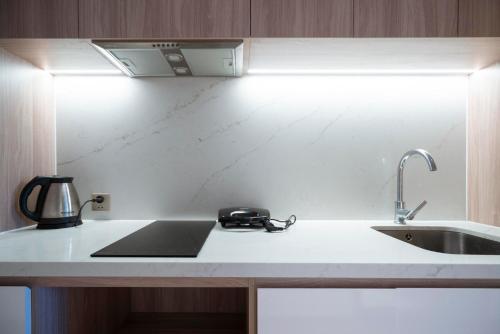 a kitchen counter with a sink and a kettle on it at A la Carte Ha Long Residences Căn hộ 5 stars cạnh biển in Ha Long