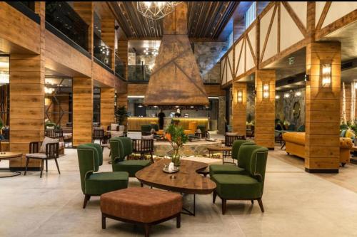 a lobby with green chairs and tables in a building at ZLATIBORSKO JEZERO 2 Lux&Spa in Zlatibor