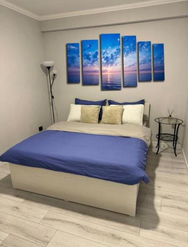- une chambre avec un lit king-size et des draps bleus dans l'établissement Апартаменты от BVO Group, à Almaty