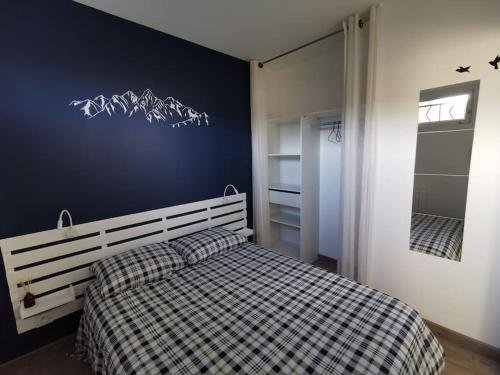 1 dormitorio con 1 cama con manta a cuadros en Logement-Barry entre Tarbes et Lourdes, 