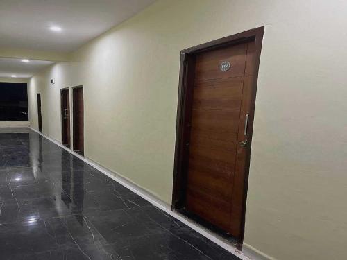 pasillo con puerta de madera en un edificio en OYO Hotel Pravin Executive, en Gangāpur