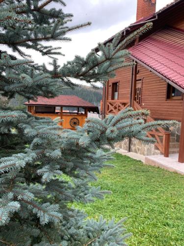 um autocarro laranja está estacionado ao lado de uma casa em Aura Karpat em Bukovel