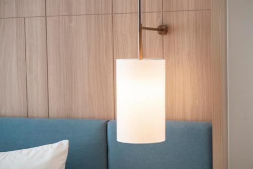 a light fixture hanging over a blue couch at A la Carte Ha Long Residences Căn hộ 5 stars cạnh biển in Ha Long