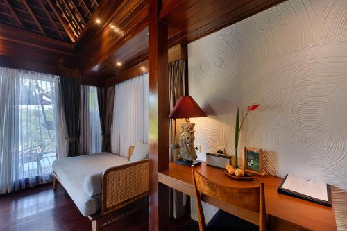 a bedroom with a desk and a bed and a desk sidx sidx sidx at Black Penny Villas Ubud in Ubud