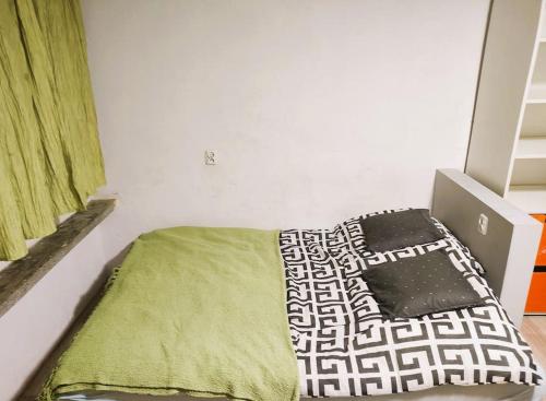 niewielka sypialnia z łóżkiem z zielonym kocem w obiekcie Forrest House w Białej w Sulejowie