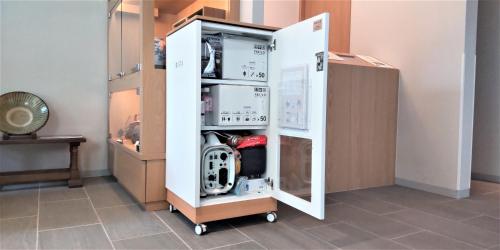 a refrigerator with a machine in a room at GRAND BASE Hiroshima Peace Memorial Park in Hiroshima