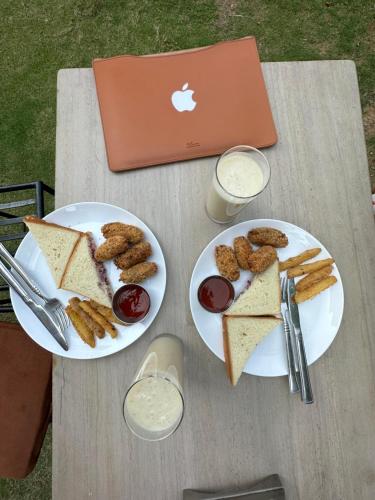 una mesa con dos platos de comida y un ordenador portátil en Hotel Bhagya, en Pokhara