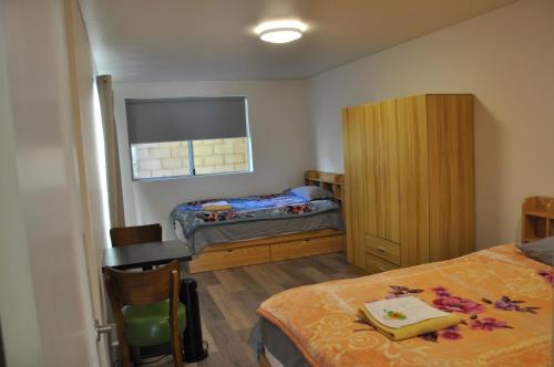 カトゥーンバにあるModern 3-bedroom Katoomba townhouse (nature view)のベッド、デスク、ベッドルームが備わる小さな客室です。