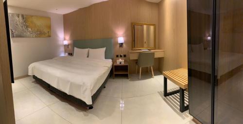 1 dormitorio con cama, escritorio y espejo en Michi Hotel - Luodong, en Luodong
