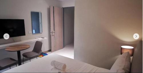 a bedroom with a bed and a table and a television at Yes Hotel San Ildefonso Bulacan in Buliran