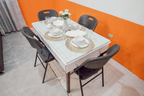 a white table with chairs and plates and flowers on it at RB Modern Condos in Zamboanga