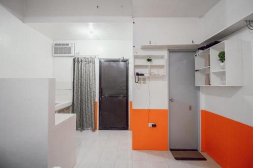 an orange and white kitchen with a refrigerator at RB Modern Condos in Zamboanga