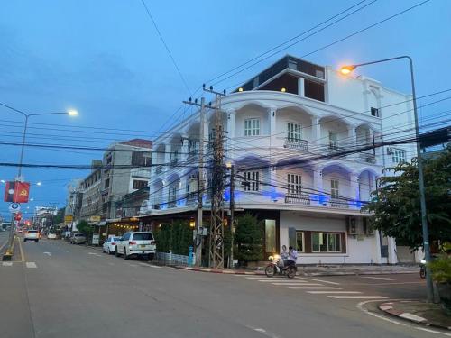 un bâtiment blanc sur le côté d'une rue dans l'établissement SUBINH HOTEL AND RESTAURANT, à Pakse