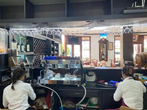 two women sitting in a kitchen preparing food at SUBINH HOTEL AND RESTAURANT in Pakse