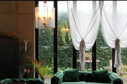 a living room with a couch and a large window at Nine Boutique Hotel in Seogwipo