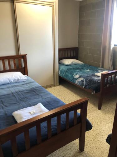 een slaapkamer met 2 bedden en een spiegel bij Unit 4 Pattison in Emu Park