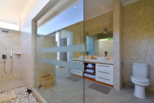 y baño con aseo, lavabo y ducha. en Deep Blue Villa Managed By LBV, en Buleleng