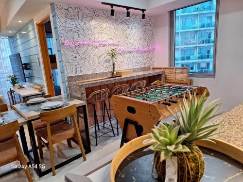 a room with a bar and a table with a game at Manila Urban Resort at Azure in Manila