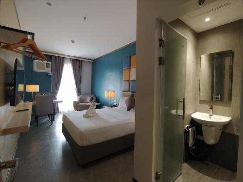 ein Hotelzimmer mit einem Bett und einem Waschbecken in der Unterkunft Yes Hotel San Ildefonso Bulacan in Buliran