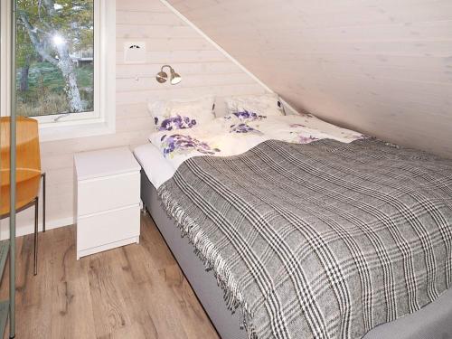 a bed in a small room with a window at 8 person holiday home in Åram in Sandvik