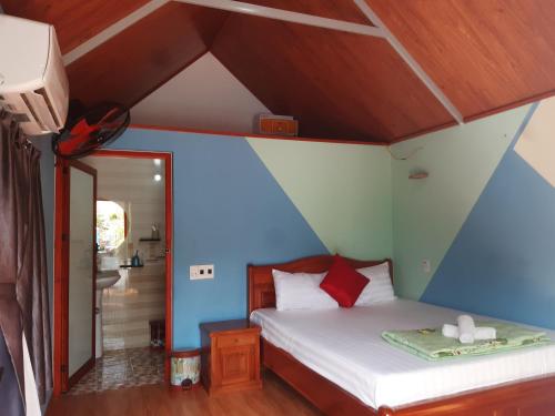a bedroom with a bed with a blue wall at Cat Ba Park Homestay in Cat Ba
