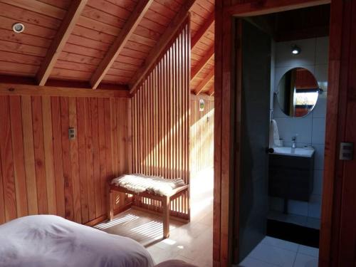 a bedroom with a bed and a bathroom with a sink at Tiny House Camino a Cascadas, Lago Llanquihue in Puerto Octay