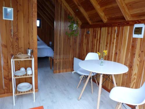 um quarto com uma mesa e cadeiras e uma cama em Tiny House Camino a Cascadas, Lago Llanquihue em Puerto Octay