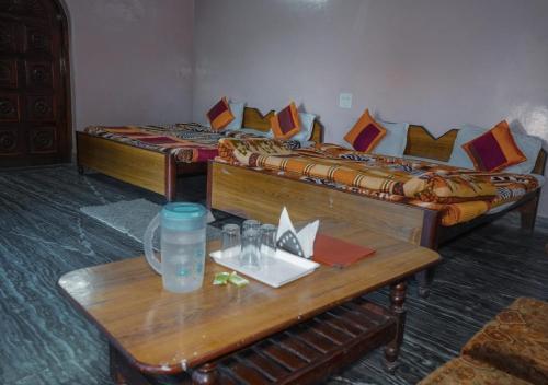 a room with two beds and a wooden table with a table sidx sidx at Himalaya Mount View Resort Uttarakhand in Kausani