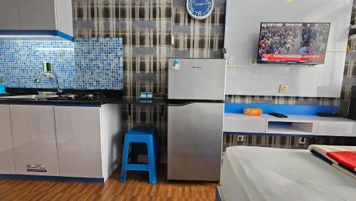 eine Küche mit einem Kühlschrank und einem blauen Stuhl in der Unterkunft Studio10 Elpis Kemayoran JIEXPO Sunrise View -Min Stay 3 nights- in Jakarta