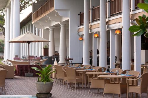 eine Reihe von Tischen und Stühlen auf einer Terrasse in der Unterkunft The Fortress Resort & Spa in Ahangama