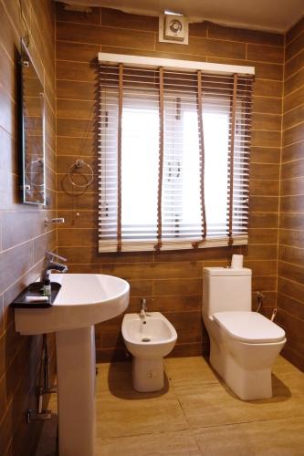 a bathroom with a sink and a toilet and a window at The GoodFind Residency in Srinagar