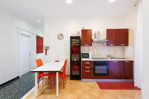 a kitchen with red cabinets and a table and chairs at Casa Vittoria di San Martino Affittacamere in Genova