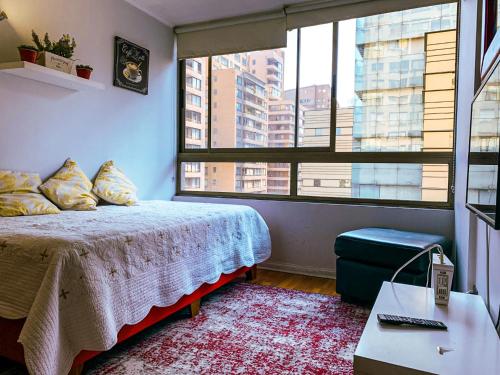 a bedroom with a bed and a large window at Depto Metro Plaza de Armas (1 dormitorio 1 baño) in Santiago