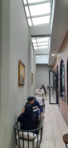 a group of people sitting in chairs in a room at Hotel Daily Inn Bandung in Bandung
