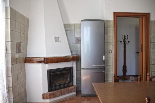 una cucina con frigorifero e camino di Villa Teresina Noli a Noli